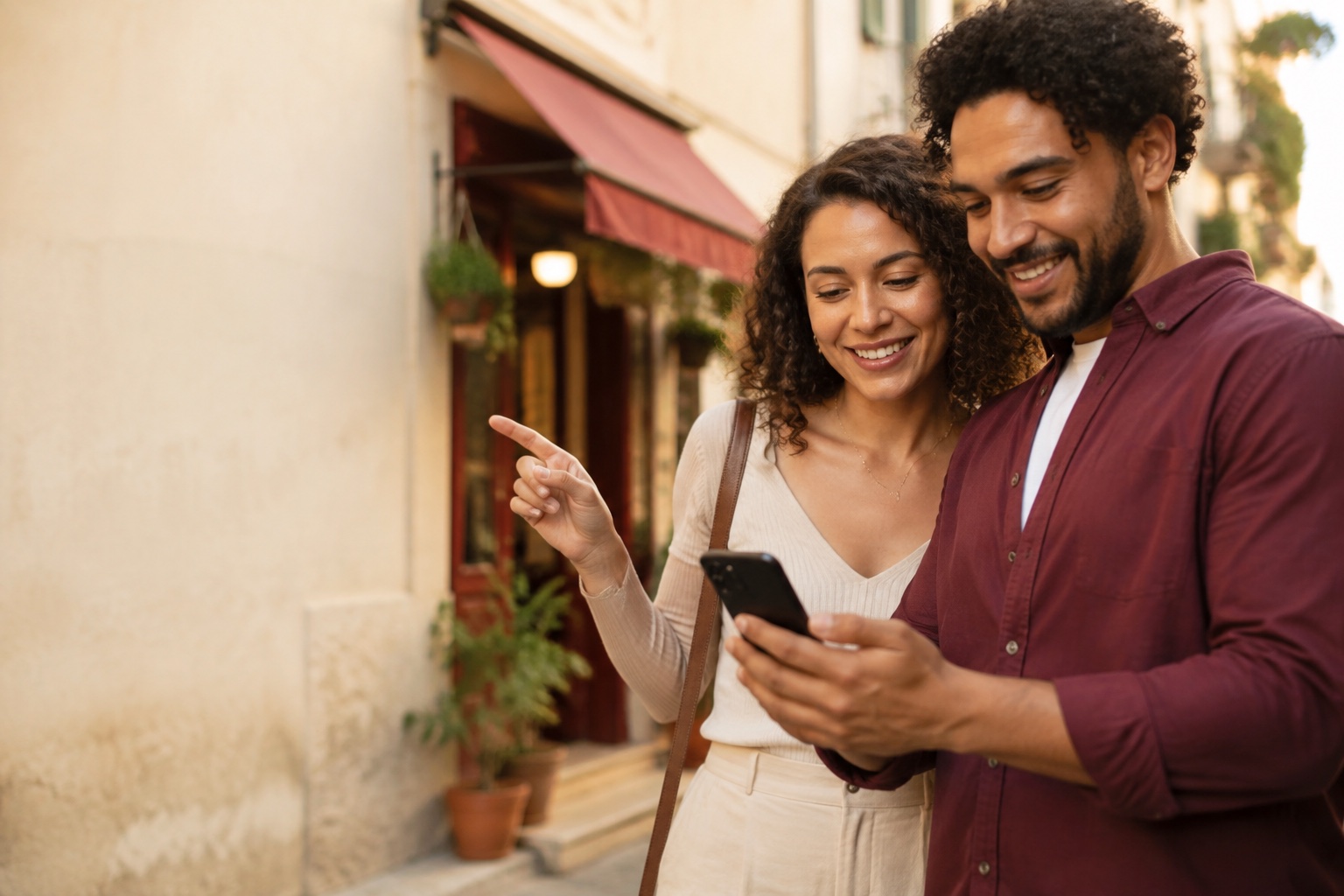 Casal consultando o celular e apontando para um café de bairro